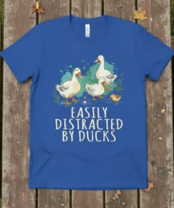Easily Distracted By Ducks text with illustration of ducks on a blue t-shirt