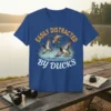 T-shirt design with text "Easily Distracted By Ducks" and graphics of mallard ducks in flight over water