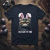 Grumpy cat wearing bunny ears with text "Easter Isn't My Thing" on a black t-shirt