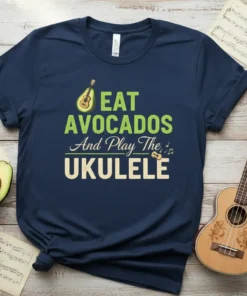 Eat Avocados And Play The Ukulele text design with avocado and ukulele graphics on a navy t-shirt