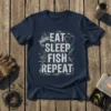Eat Sleep Fish Repeat text design with fish, fishing lures, and reel on a navy t-shirt