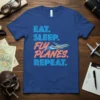 Blue t-shirt with "EAT. SLEEP. FLY PLANES. REPEAT." text and a graphic of a flying airplane