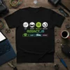 Black t-shirt with Eat Sleep React.js Repeat design featuring icons for food, sleep, React logo, and refresh symbol, along with