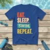 Eat Sleep Swim Repeat text design on a blue t-shirt, with bold typography and swimming-related accessories