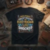 Black t-shirt with "When People Find Out How Bad An Electrician I Am They're Shocked" in yellow and blue typography