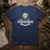 Ellessdee text with a colorful hot air balloon graphic above a decorative banner on a navy blue t-shirt