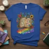 Equality Hurts No One t-shirt design with open book listing virtues and LGBTQ+ symbols, surrounded by flowers and butterflies