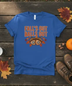 Blue t-shirt with orange text "FALL'S OUT BALL'S OUT" and an acorn graphic with autumn leaves