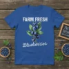 Farm Fresh Blueberries text with a watercolor illustration of blueberries and leaves on a blue t-shirt