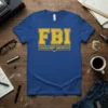 FBI Female Body Inspector t-shirt with bold yellow text on a royal blue shirt, featuring distressed vintage lettering