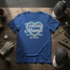 Fencing Mama Like a regular mom but cooler quote on a blue t-shirt, surrounded by fencing gear