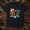 Black t-shirt featuring the number 67 designed with Christmas lights, pine branches, and a Santa hat, with ice crystals at