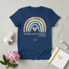 Navy blue t-shirt with a pastel rainbow graphic and rose gold heart, text reads "FIGHTING FOR MY RAINBOW #IVFSTRONG" with