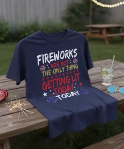 Navy blue t-shirt with white, yellow, and red text reading "FIREWORKS ARE NOT THE ONLY THING GETTING LIT TODAY" with
