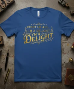 Blue t-shirt with gold glitter text reading "FIRST OF ALL... I'M A DELIGHT. I'M A DELIGHT." in a decorative font