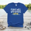 Floats Well With Others quote with three yellow rubber ducks swimming in blue water waves on a royal blue t-shirt