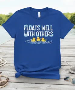 Floats Well With Others quote with three yellow rubber ducks swimming in blue water waves on a royal blue t-shirt
