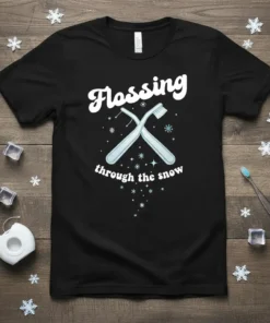 Black t-shirt with white text "Flossing through the snow" and crossed blue toothbrushes with snowflakes