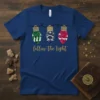 Follow The Light Christmas T-Shirt with a nativity scene inside three illuminated bulbs. Features Jesus' birth story in a religious
