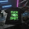 Black t-shirt with "FUCK THIS SHIT" in neon green glitch-style text, featuring a central burst graphic