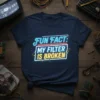 T-shirt with neon-style text "FUN FACT: MY FILTER IS BROKEN" in white and yellow, on a navy blue shirt