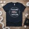 Future Mrs. Taylor text design in a circle with rose gold Mrs. script on a navy t-shirt