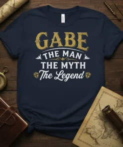 Navy t-shirt with "Gabe The Man The Myth The Legend" text in distressed gold and white font, featuring knight shield