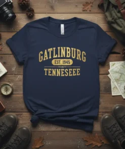 Navy blue t-shirt with "GATLINBURG EST. 1945 TENNESEEE" in distressed gold font, vintage travel design