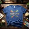 Blue t-shirt with "gay son" in glitter gold text, surrounded by a rainbow heart and colorful bursts