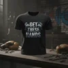 Black t-shirt with "GET THESE HANDS" text and graphic of clenched fists within gears, gym background