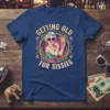 Getting Old For Sissies humorous quote t-shirt featuring a stylish older woman flexing with a cocktail
