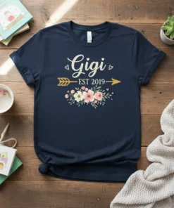 Navy blue t-shirt with "Gigi EST 2019" text, floral graphics, and golden arrow design