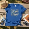 Girls Trip 2021 text with palm trees and mountains graphic on a blue t-shirt
