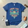 Girls' Trip Miami 2025 text graphic with palm trees, hibiscus flowers, and a sunset design on a blue t-shirt