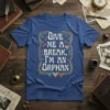 "Give Me A Break, I'm An Orphan" quote t-shirt with decorative border and colorful hearts, presented on a blue tee