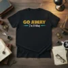 Black t-shirt with "GO AWAY I'm Writing" text in gold and white script font, ideal for writers and authors