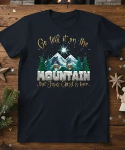 Go tell it on the MOUNTAIN that Jesus Christ is born text on a dark blue t-shirt with a Christmas