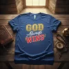 Blue t-shirt with "GOD Always WINS" text in gold and red, featuring sunburst graphic and laurel wreaths