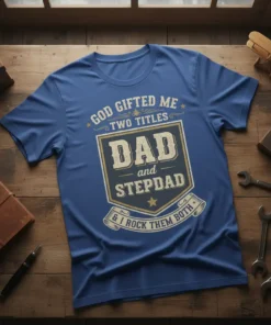 Blue t-shirt with text "God Gifted Me Two Titles Dad and Stepdad & I Rock Them Both" in a shield