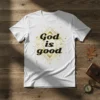 White t-shirt with "God is good" text in bold black font, surrounded by a golden geometric starburst design