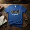 GOD is good quote in gothic and script fonts with gold floral accents on a blue t-shirt