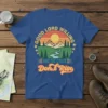 Retro t-shirt design with text "GOOD LORD WILLING AND THE CREEK Don't Rise" over a mountain landscape graphic