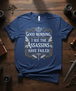 Good Morning, I See The Assassins Have Failed quote t-shirt with decorative border and sword graphic