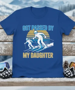 Got Passed By My Daughter skiing quote on a blue t-shirt, featuring two skiers and a sunset graphic