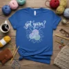 Blue t-shirt with "got yarn?" text and graphic of yarn balls and knitting needles