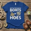 Gotta Have Me My Boats 'N' Hoes text with sailboat and women graphic on a blue t-shirt