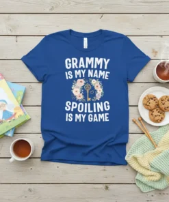 White text "Grammy Is My Name Spoiling Is My Game" on a royal blue t-shirt, with a floral wreath and