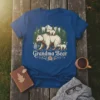 Grandma Bear t-shirt design with a mother bear and two cubs walking in a forest setting