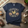 Grandma Hen t-shirt with a golden hen illustration surrounded by pink roses and vintage lettering
