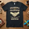 Grandpa and Grandson A Bond That Can't Be Broken text with handshake graphic on black t-shirt